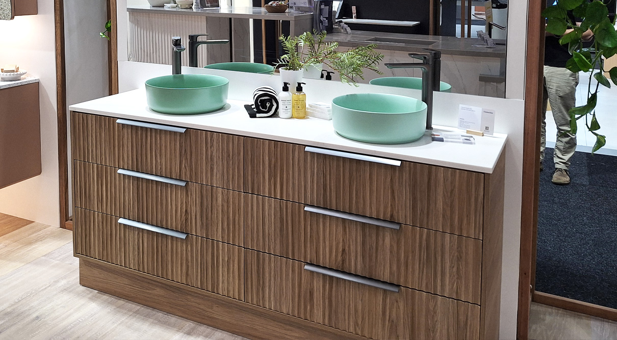 Emmett 1800mm double bowl floorstanding vanity in Prime Oak with Apollo routed front. Paired with an Albastera SilkSurface top and Mint Matte Allure Ceramic basins. Featuring Gunmetal 350mm Loft handles and complemented by Villeroy & Boch O.Novo Vessel Basin Mixers in Gunmental.